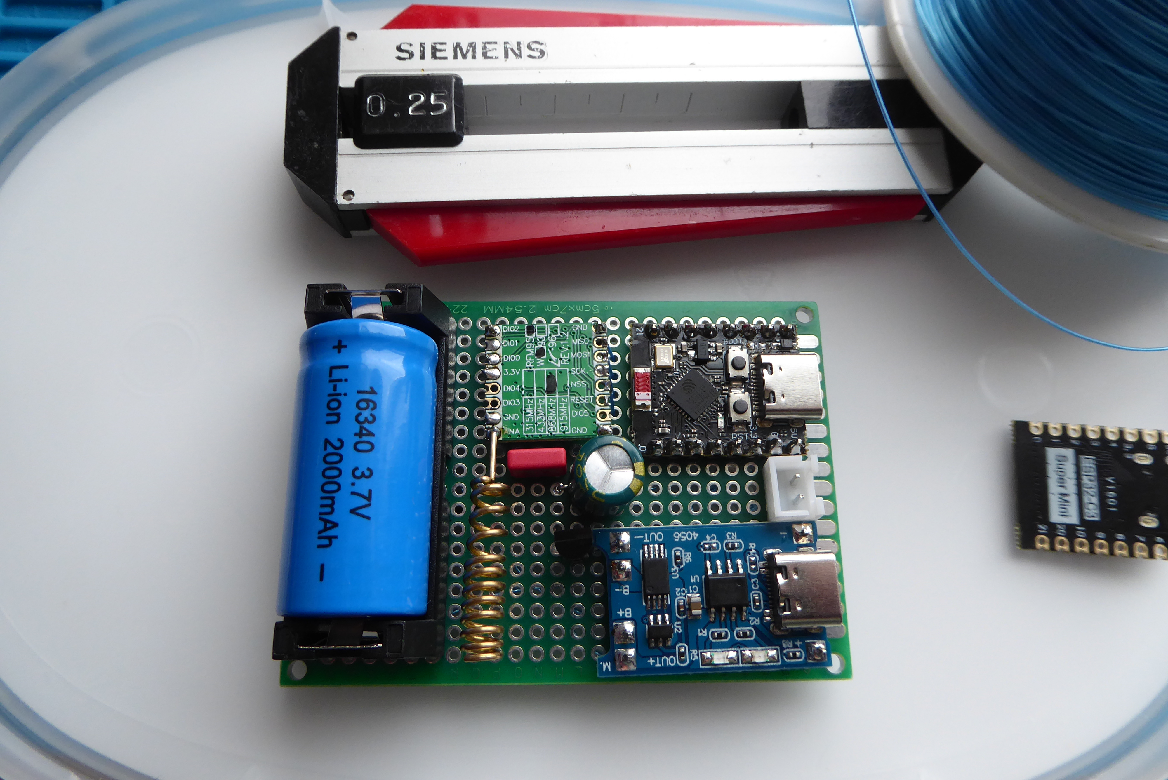 PCB:n komponenttipuoli: 16340-akku, ESP32-C3, TP4056, RFM95W